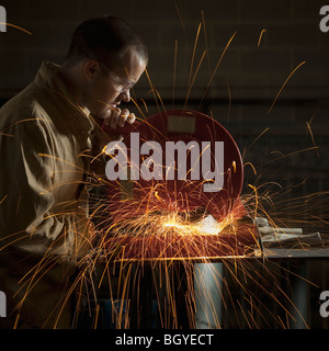 Steel grinder working in metal shop Stock Photo