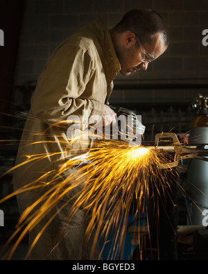 Steel grinder working in metal shop Stock Photo
