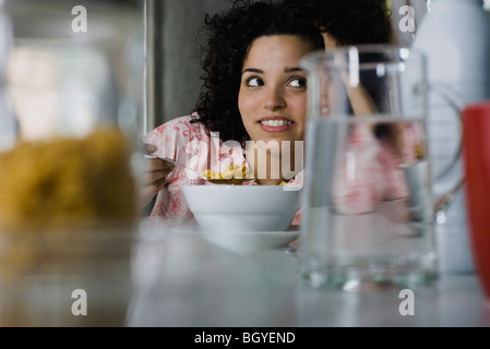 Young woman daydreaming at breakfast table Stock Photo