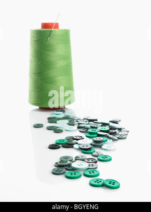 Spools of thread and buttons with needle Stock Photo - Alamy