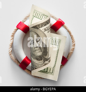 Ring bouy behind American currency Stock Photo