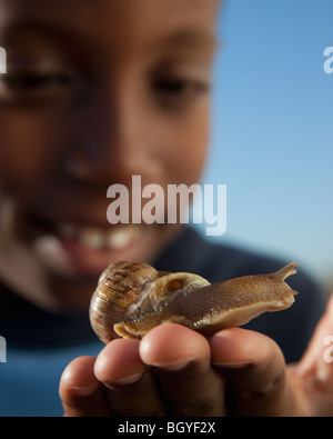 Young boy holding snail Stock Photo