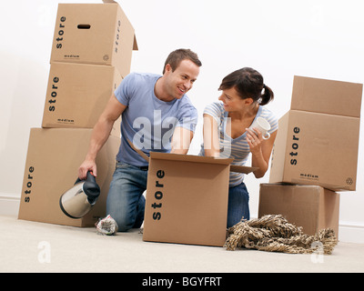 Couple unpacking kitchenware from boxes Stock Photo
