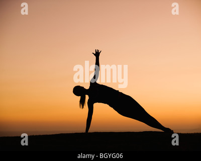 Silhouette of woman doing yoga Stock Photo