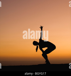 Silhouette of woman doing yoga Stock Photo