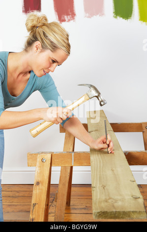 Woman hitting nail Stock Photo