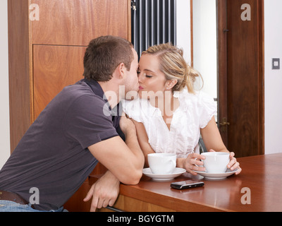 Couple kissing in kitchen Stock Photo