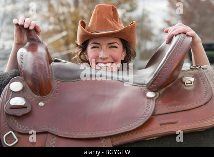 Woman holding saddle Stock Photo