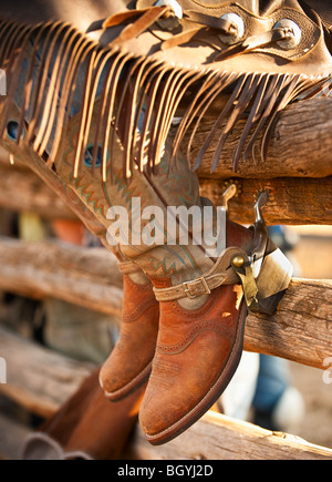 Cowboy boots on fence Stock Photo