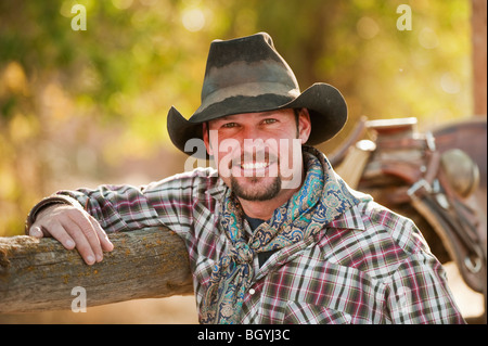 Cowboy leaning on fence