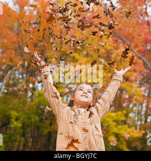Girl throwing leaves Stock Photo
