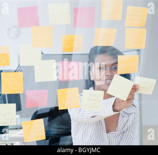 Woman looking at post-it notes Stock Photo