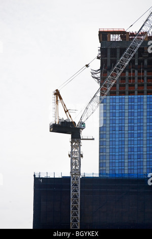 Crane beside high-rise building Stock Photo