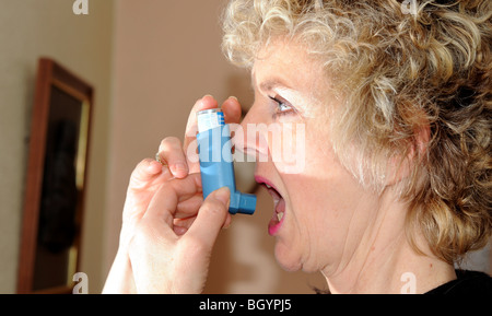Someone Using Blue Inhaler Woman using a blue inhaler to help with her asthma short of breath ...