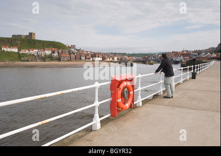 Man looking across the harbour at Whitby, towards St. Mary's Church. Stock Photo