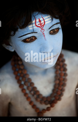 Indian boy, face painted as the Hindu god Shiva against a black background. India