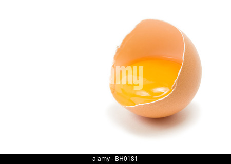 Single cracked open Hens Egg showing yolk isolated against white background Stock Photo
