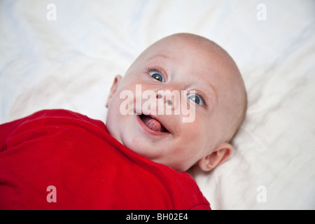 Baby boy in a red tee-shirt sticking his tongue out  London, England Stock Photo