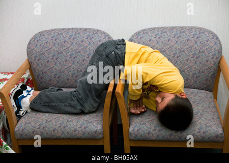 7-8 years old Hispanic  adhd boy waiting for his appointment with the doctor. MR  © Myrleen Pearson Stock Photo