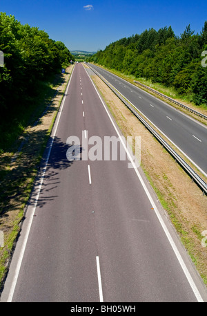 Empty dual carriageway road with white lines and crash barrier in centre Stock Photo