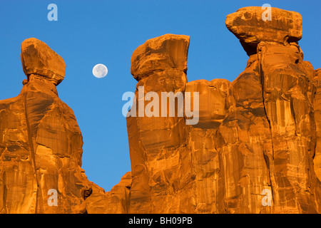 Near full moon along with the Three Gossips, Arches National Park, near Moab, Utah. Stock Photo