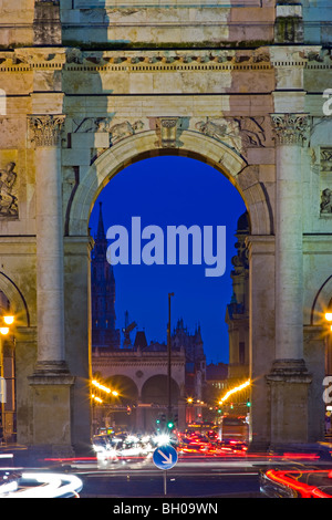 Centre arch of the Siegestor (Victory Gate) with traffic flowing towards and away from it at dusk in the Schwabing district in t Stock Photo