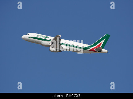 Air travel. Alitalia Airbus A320 commercial jet plane in flight on departure against a clear blue sky Stock Photo