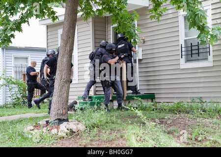 Police from tactical team making entry to serve a high-risk drug ...