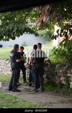 Police officers from tactical squad talking to suspect. Street Narcotics Unit Tactical Squad, Kansas City, MO, Police. Stock Photo