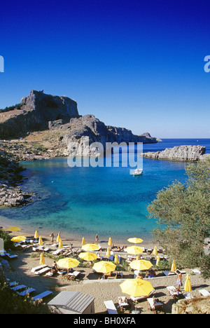 Sunshades on the beach of Agios Pavlos Bay under blue sky, Acropolis, Lindos, Island of Rhodes, Greece, Europe Stock Photo