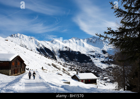 Couple walking on a path above the resort of Verbier, Valais, Switzerland