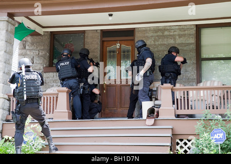 Police tactical team making entry serving a high risk drug related search warrant. Street Narcotics Unit, Kansas City, MO, PD. Stock Photo