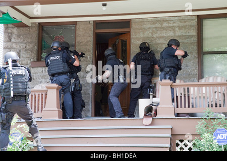 Police tactical team making entry serving a high risk drug related search warrant. Street Narcotics Unit, Kansas City, MO, PD. Stock Photo