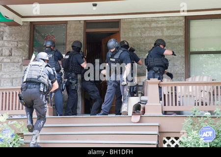 Police tactical team making entry serving a high risk drug related search warrant. Street Narcotics Unit, Kansas City, MO, PD. Stock Photo