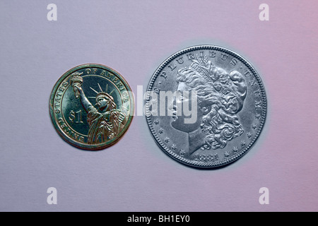 One Dollar Coin (left) and an 1881 Morgan Silver Dollar (right). Stock Photo