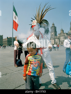 A man wearing an aztec costume and people at the square in front of the cathedral, Zocalo, Mexico City, Mexico, America Stock Photo