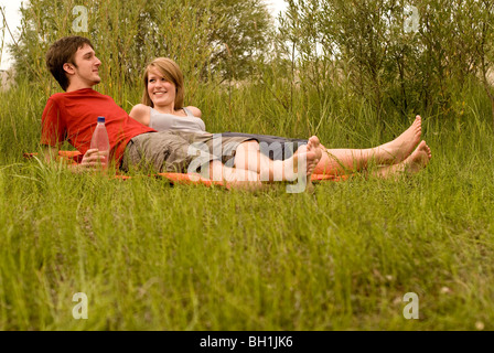Teenage couple lying in meadow, Freising, Bavaria, Germany Stock Photo