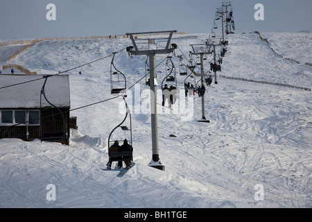 Skiers on chairlift at Glenshee ski resort in the Grampians, near Braemar, in the Cairngorms National Park,  Aberdeenshire, Scotland, UK Stock Photo
