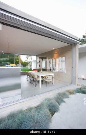 Glass wall of open plan dining / kitchen area in Palm Springs home Stock Photo