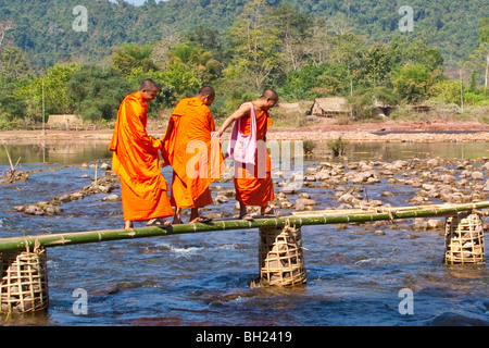 Monks crossing a river near Vang Vieng, Laos Stock Photo