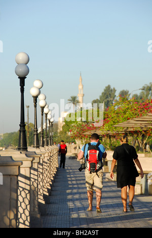 LUXOR, EGYPT. An evening view of two tourists walking along the Corniche by the River Nile. Stock Photo
