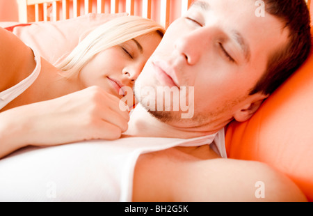 Cropped close-up of man and woman sleeping close together in bed. Horizontal format. Stock Photo
