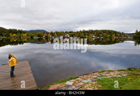 Woman exulting in a feeling of freedom, being close t nature. Lake Saranac, Adirondack State Park, Upper New York State, USA Stock Photo