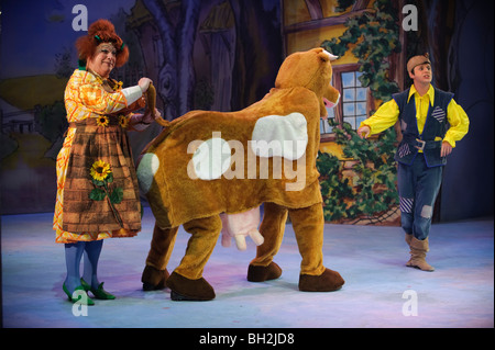 A production of Jack and the Beanstalk, panto dame milking the traditional pantomime cow Stock Photo