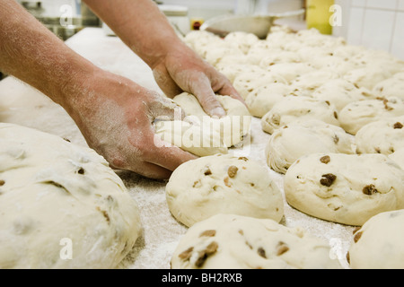 Two hands working on rolls in a bakery Stock Photo