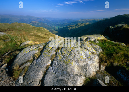 A view in summer in the Lake District National Park looking towards Helm Crag and Grasmere Village from Grasmere Common Stock Photo