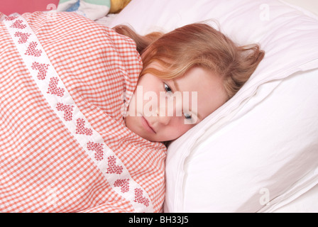 Young girl awakes in her bed at night UK Stock Photo