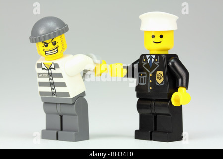 Lego policeman arresting a criminal Stock Photo