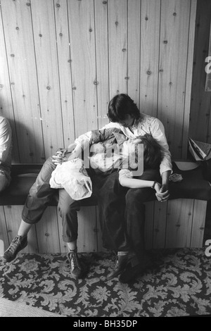 1970s  teenagers Asian boy with white girl inside mini cab office waiting room. Tower Hamlets, East London UK 1978 HOMER SYKES Stock Photo