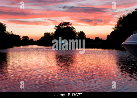 Sunset on the Thames at Shillingford Bridge Oxford with motor cruiser coming downstream Stock Photo